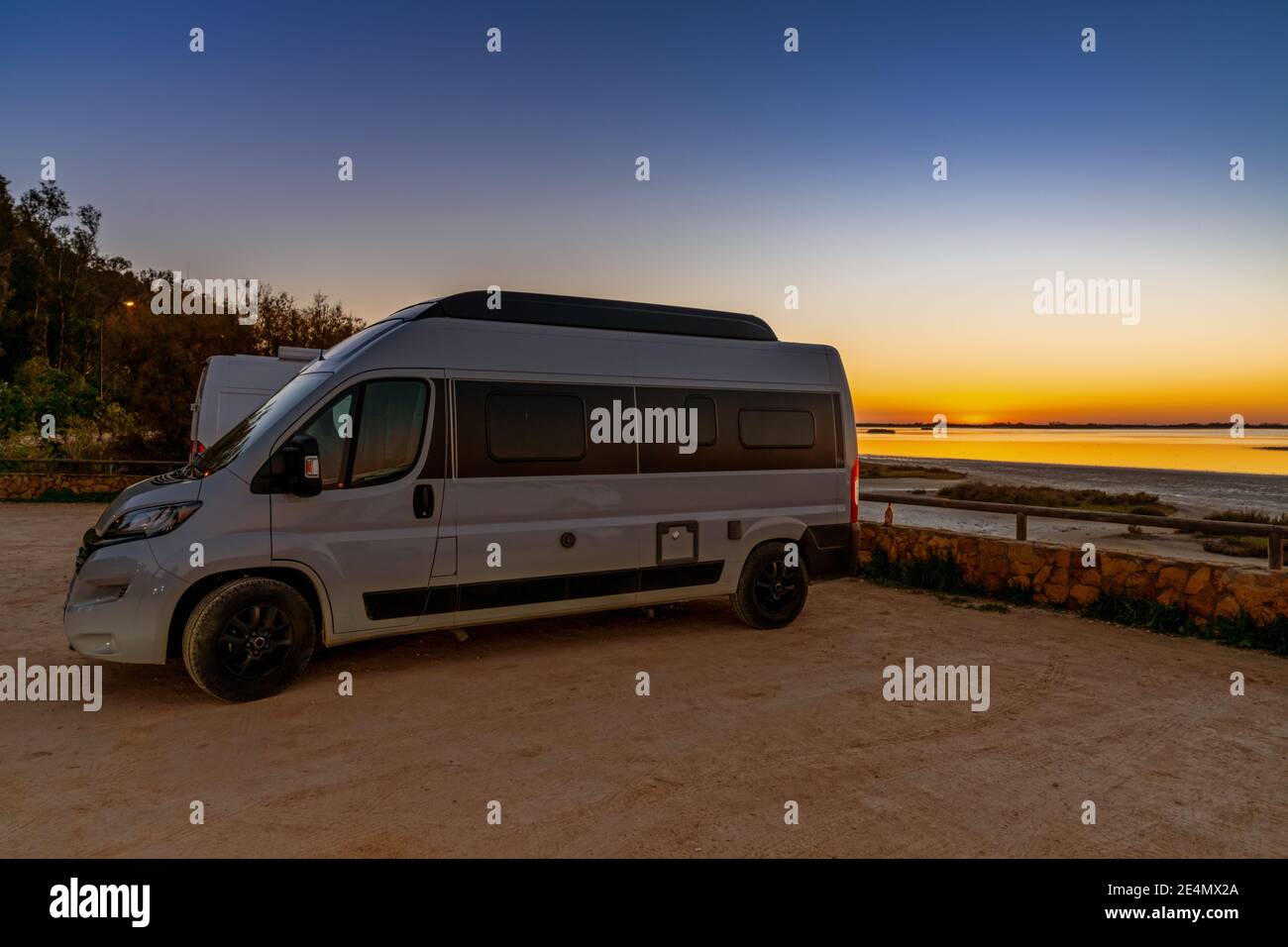 San Fernando, Spagna - 16 gennaio 2021: Nightfall con un cielo colorato su zone umide e canali paesaggio naturale e un camper in primo piano Foto Stock