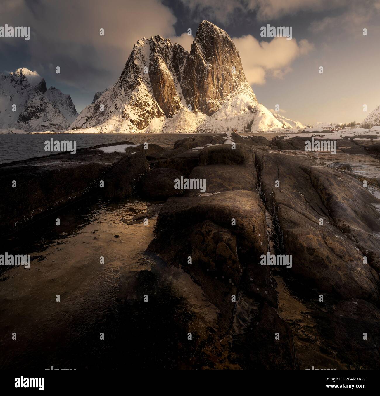 EPIC Hannoy picchi durante un freddo alba invernale, riflessa in piscine ghiacciate, Lofoten, Norvegia Foto Stock