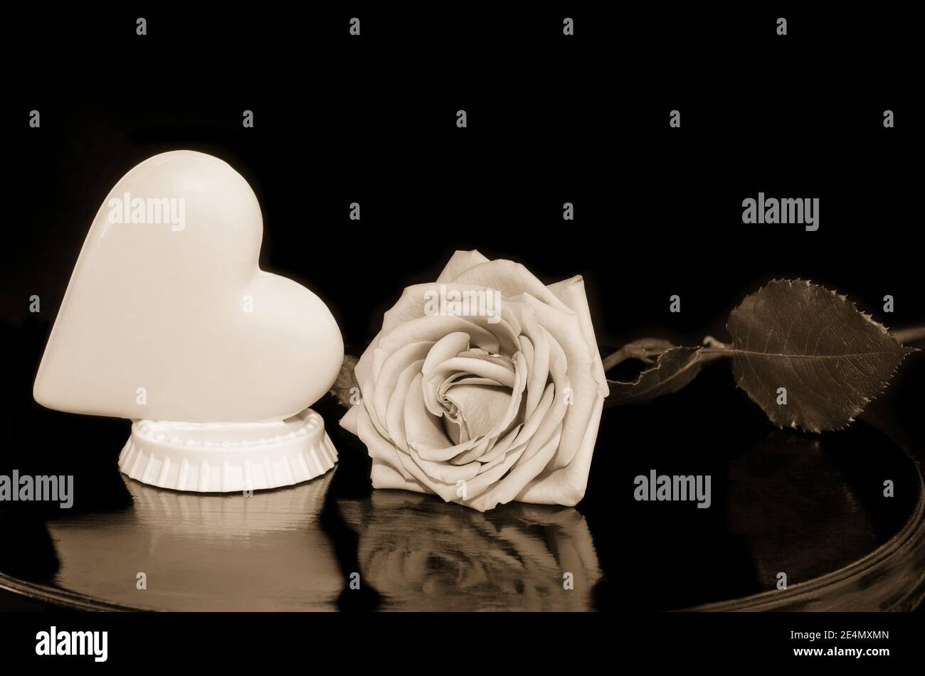 Cuore al cioccolato e rosa per San Valentino, tinta seppia Foto Stock
