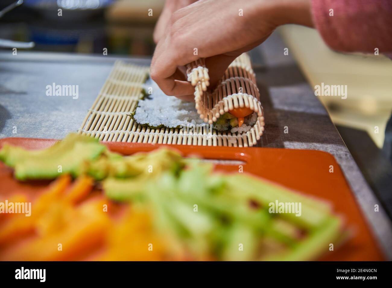 Primo piano di una persona che prepara cibo giapponese. Primo piano di una persona che prepara panini di sushi. Foto Stock