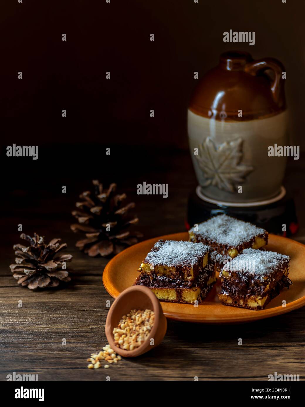Dessert fatti in casa con pan di Spagna, cioccolato, fiocchi di cocco, cacao e nocciole tritate, su sfondo scuro Foto Stock