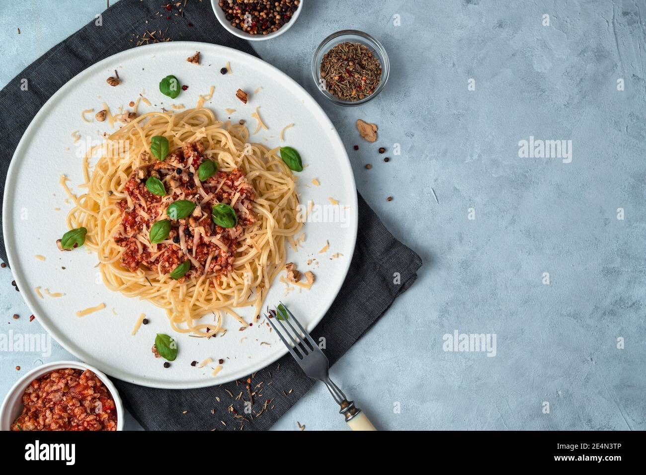 Pasta con salsa su un piatto bianco piatto su fondo grigio. Foto Stock