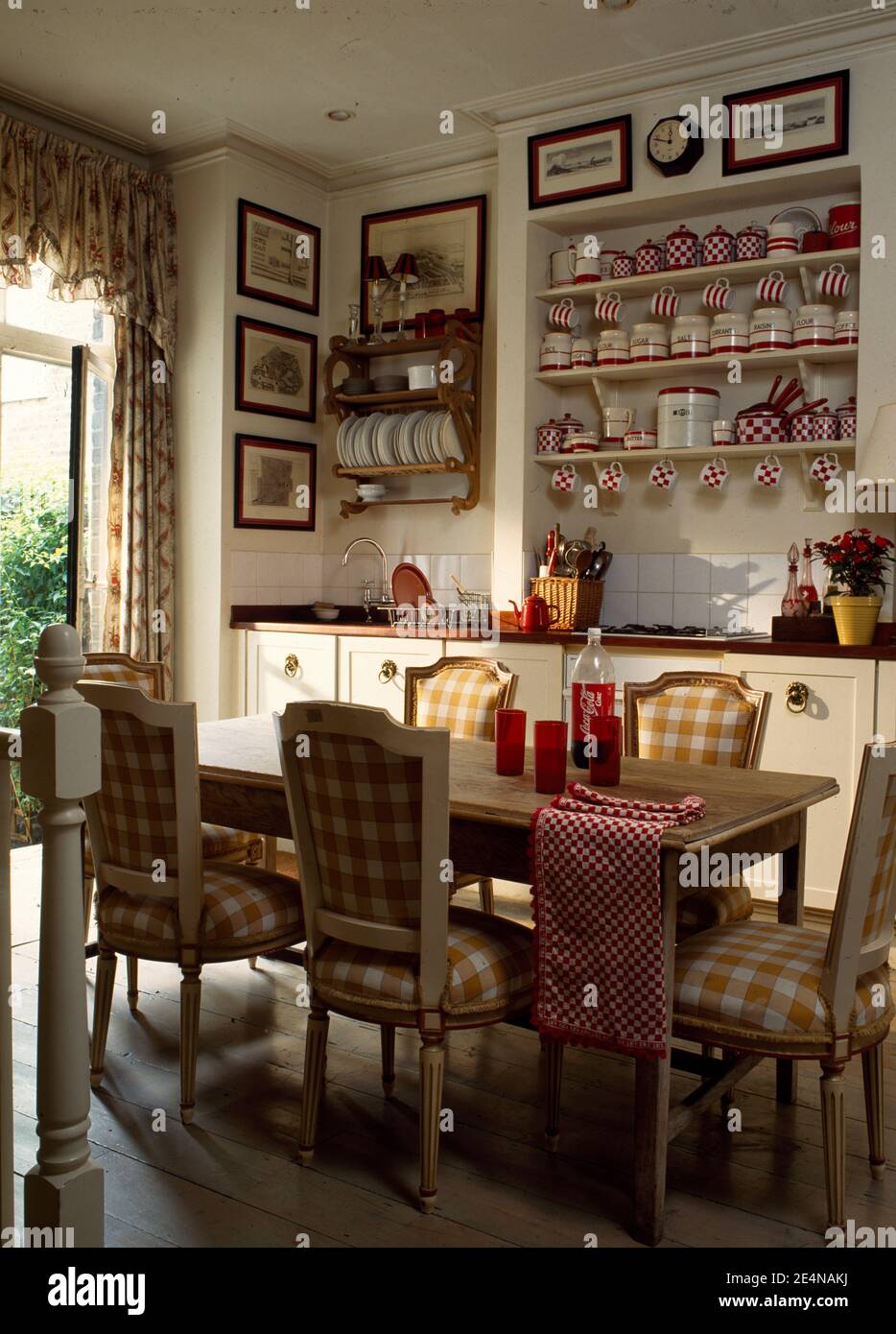 Tavolo in pino e sedie imbottite in tessuto di controllo in cucina tradizionale sala da pranzo con vista sul giardino Foto Stock