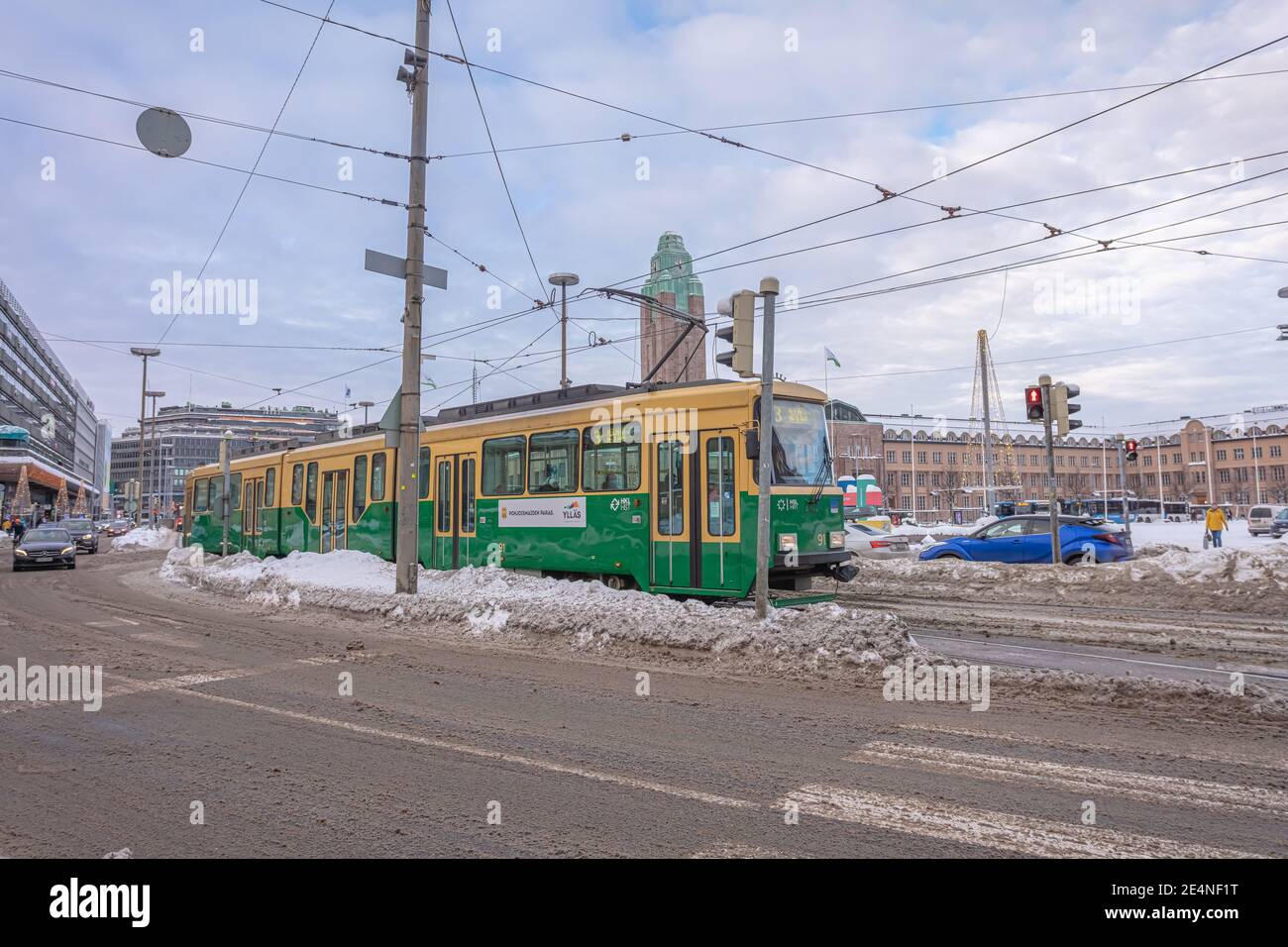 Helsinki. Finlandia. 19 gennaio 2021 Snowy Helsinki. Tram moderno su una strada innevata d'inverno. Vecchie facciate colorate di edifici sulla strada coperta di neve in inverno in città. Concetto di trasporto. Contrasto tra vecchio e nuovo. Foto di alta qualità Foto Stock