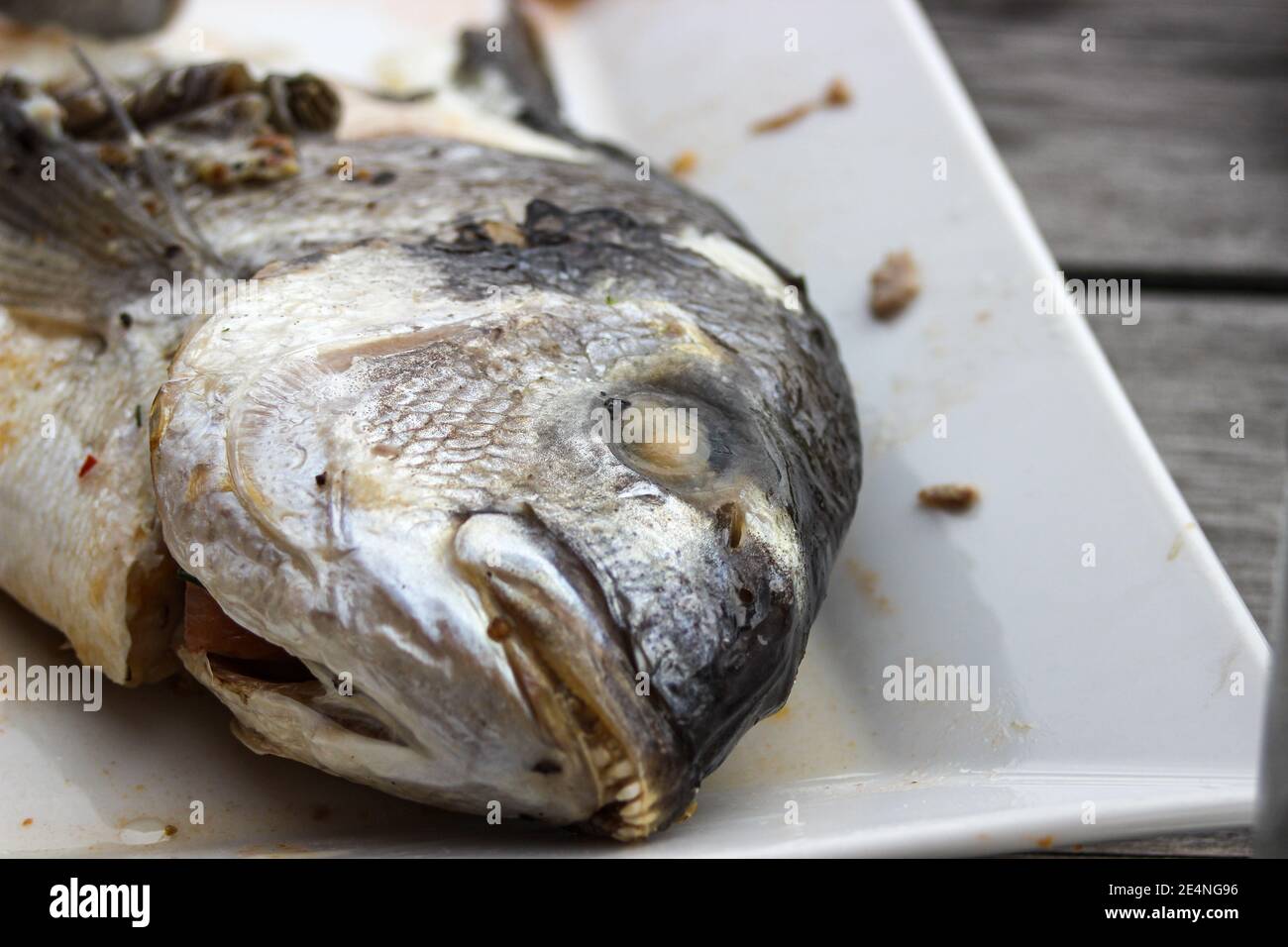 Primo piano di un piatto di pesce finito, fuoco selettivo Foto Stock