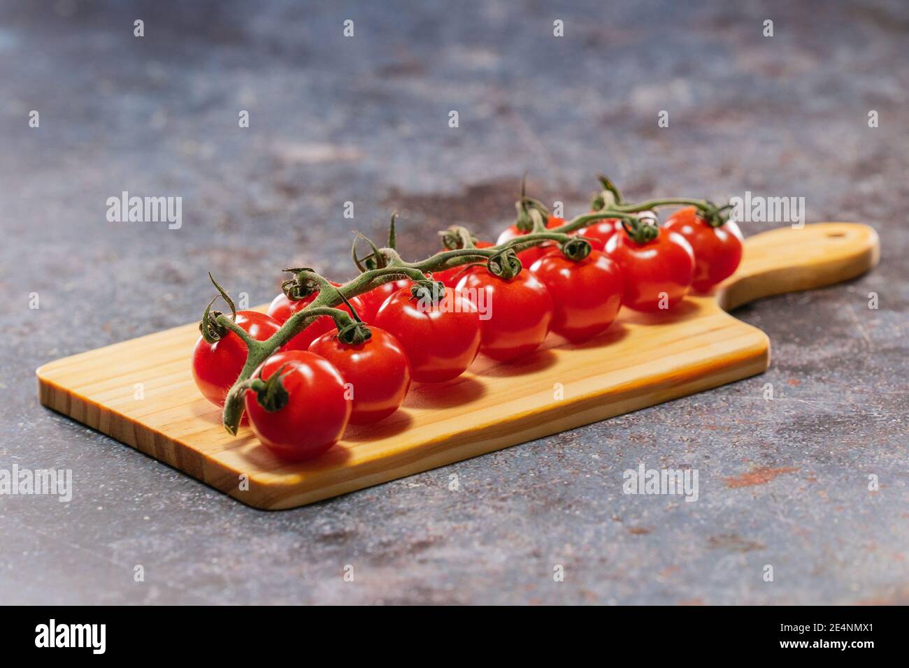 Alto sapore, bello nel colore e di piccole dimensioni i pomodori piccoli britannici giacenti sul tagliere Foto Stock
