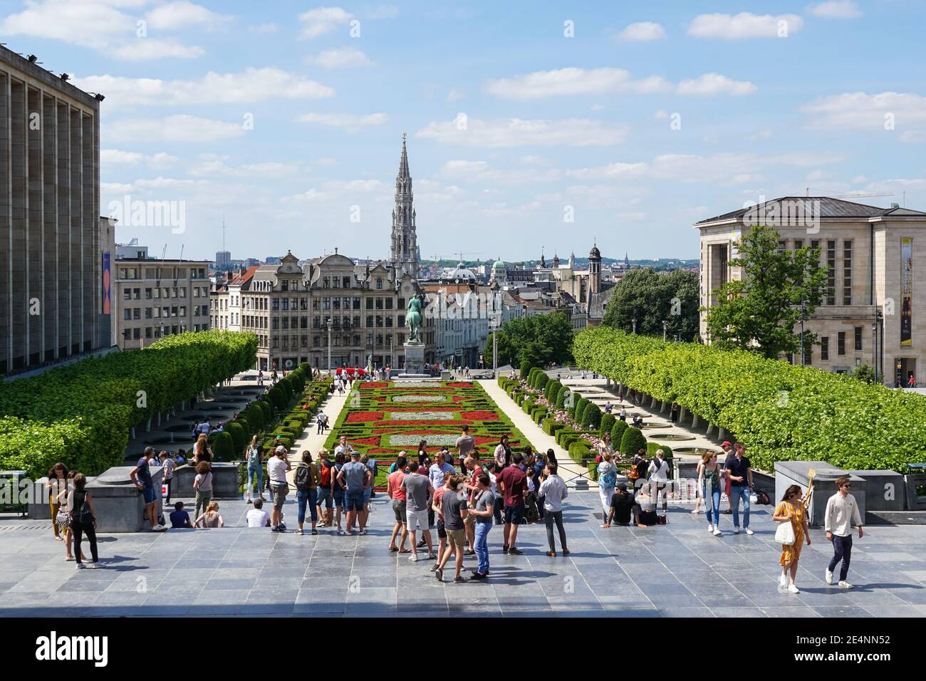 Le persone che godono di vista sul giardino del Mont des Arts con la guglia del municipio sullo sfondo a Bruxelles, Belgio Foto Stock