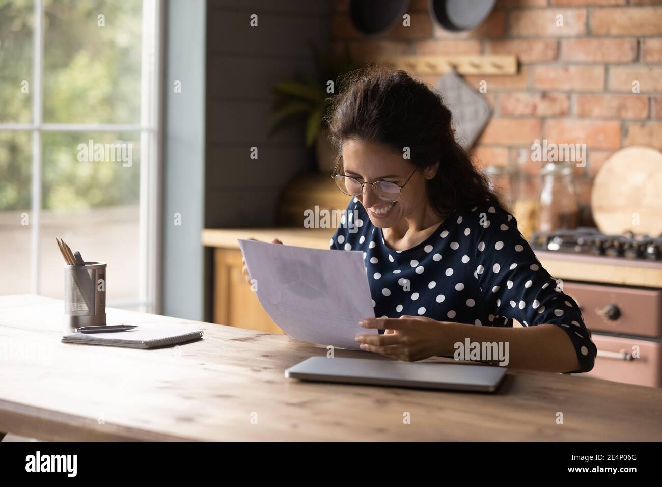 La giovane donna con grande gioia trionfa leggendo le buone notizie nel documento Foto Stock