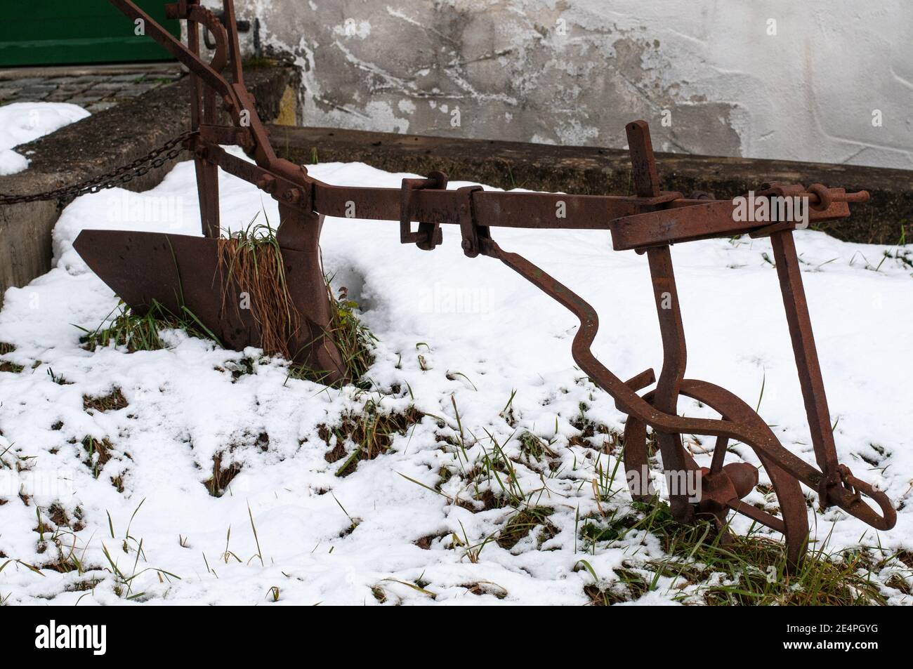 un vecchio aratro coperto di ruggine come decorazione in a. giardino di semina Foto Stock