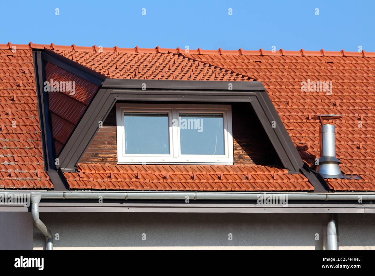 Nuovi finestrini del tetto con telaio in plastica bianca accanto al lucido  camino in metallo in