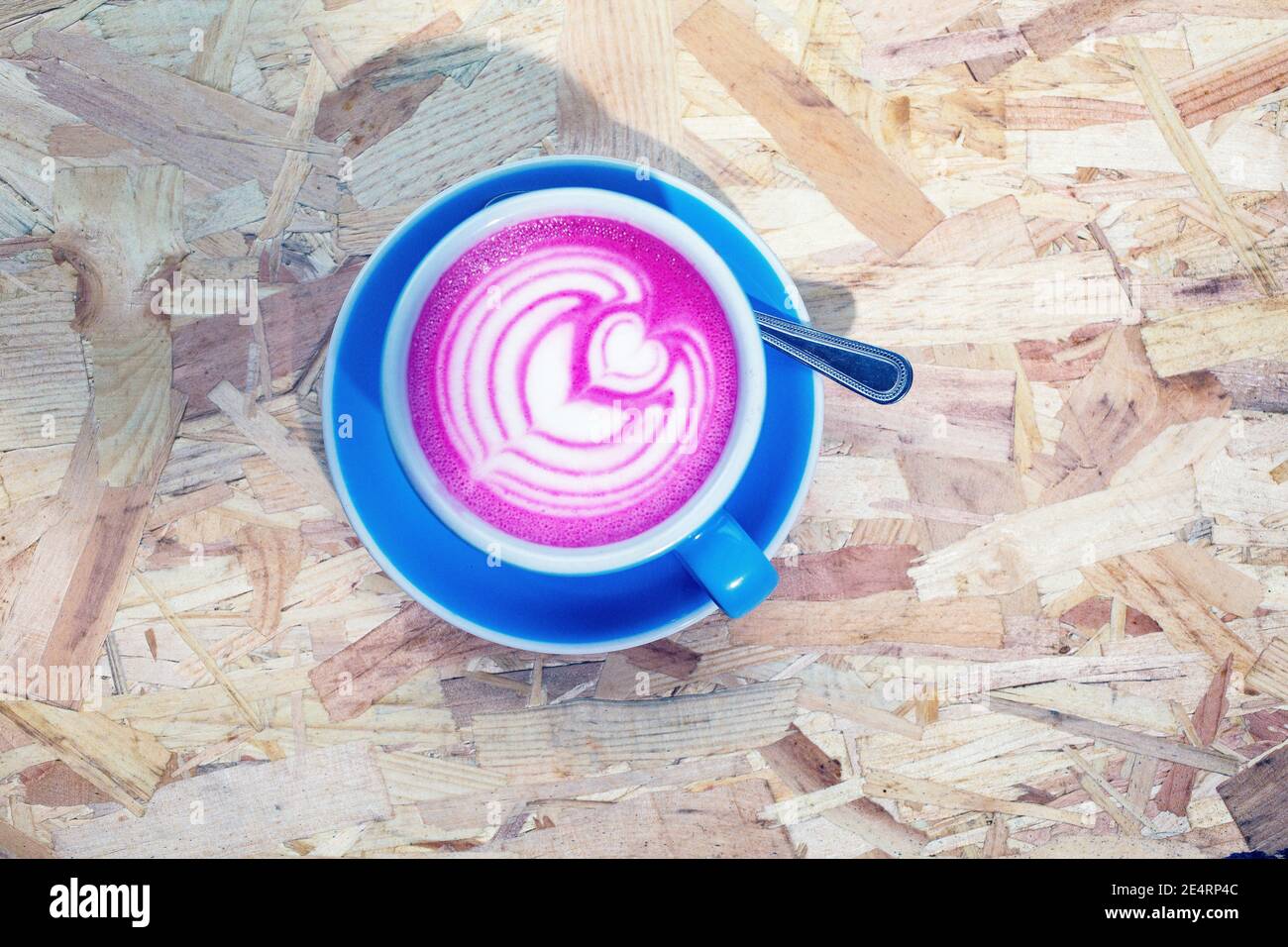 latte di barbabietola alla moda con latte art e petali di fiori su la gomma espansa Foto Stock