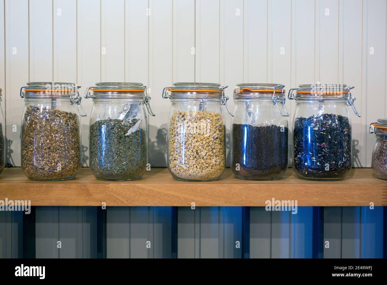 Cucina rustica disposizione di deposito del tè in vasi di vetro con sfondo di legno bianco. Foto Stock