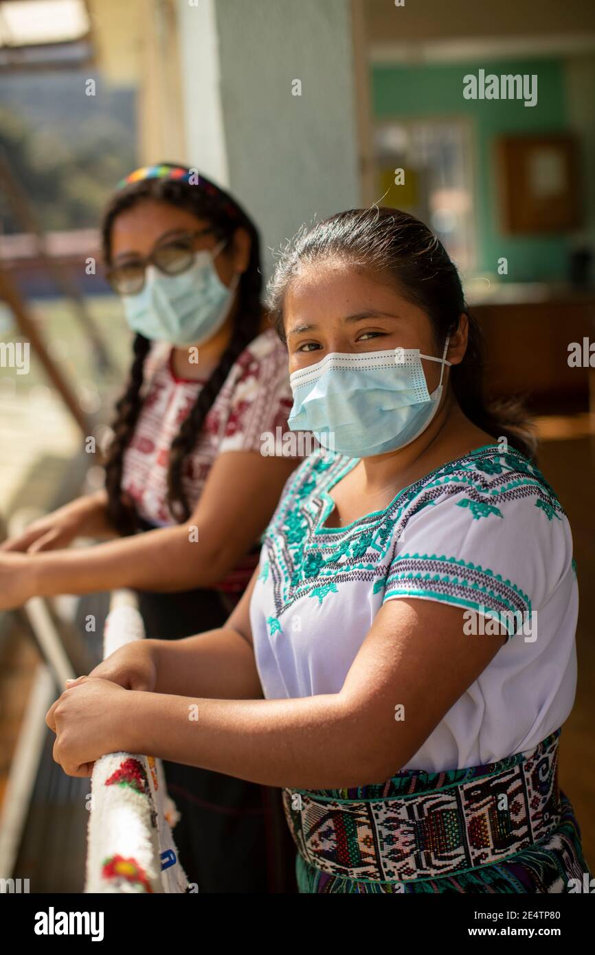Giovani donne che indossano maschere protettive a San Juan la Laguna, Guatemala, America Centrale. Foto Stock
