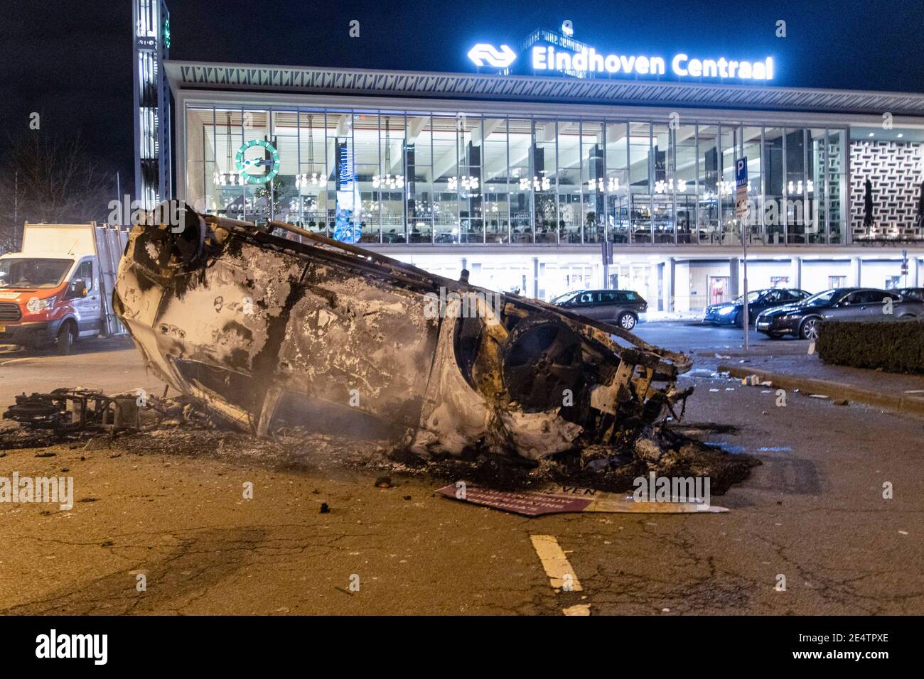 Dopo la dimostrazione, un'auto del ProRail è bruciata di fronte alla stazione ferroviaria centrale di Eindhoven. Detriti sulle strade di Eindhoven, il seguito di una manifestazione contro il nuovo Coronavirus Covid19 misure di copertura dopo il blocco. Gli scontri tra i manifestanti e gli agenti di polizia hanno portato alla combustione di un'auto, alla rottura delle finestre, al lancio di pietre e alla messa a punto di blocchi stradali con biciclette in fiamme, mentre la stazione ferroviaria centrale è stata danneggiata. La polizia ha fatto 55 arresti. Il coprifuoco è stato imposto tra le 21:00 e le 04:30 ora locale. Foto Stock