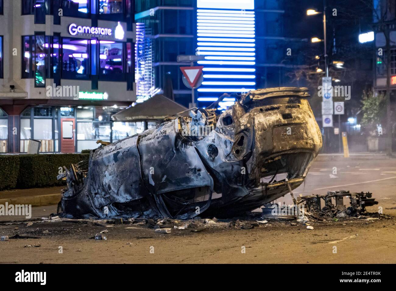 Dopo la dimostrazione, un'auto del ProRail è bruciata di fronte alla stazione ferroviaria centrale di Eindhoven. Detriti sulle strade di Eindhoven, il seguito di una manifestazione contro il nuovo Coronavirus Covid19 misure di copertura dopo il blocco. Gli scontri tra i manifestanti e gli agenti di polizia hanno portato alla combustione di un'auto, alla rottura delle finestre, al lancio di pietre e alla messa a punto di blocchi stradali con biciclette in fiamme, mentre la stazione ferroviaria centrale è stata danneggiata. La polizia ha fatto 55 arresti. Il coprifuoco è stato imposto tra le 21:00 e le 04:30 ora locale. Foto Stock