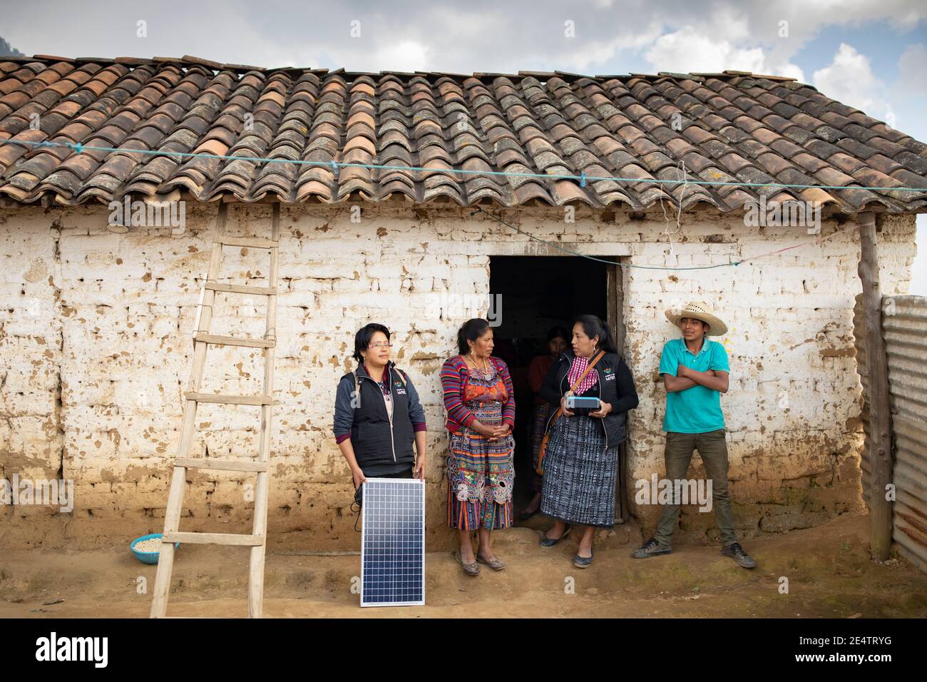 Un tecnico della società locale di energia senza scopo di lucro installa un nuovo sistema di illuminazione a energia solare in una casa a Cantel, Guatemala. Foto Stock