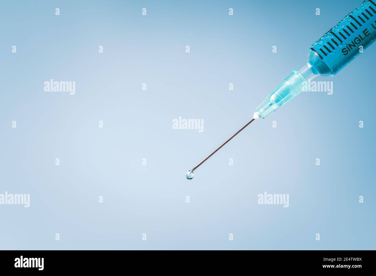 Siringa chiusa su sfondo blu, concetto di apparecchiatura medicale Foto Stock