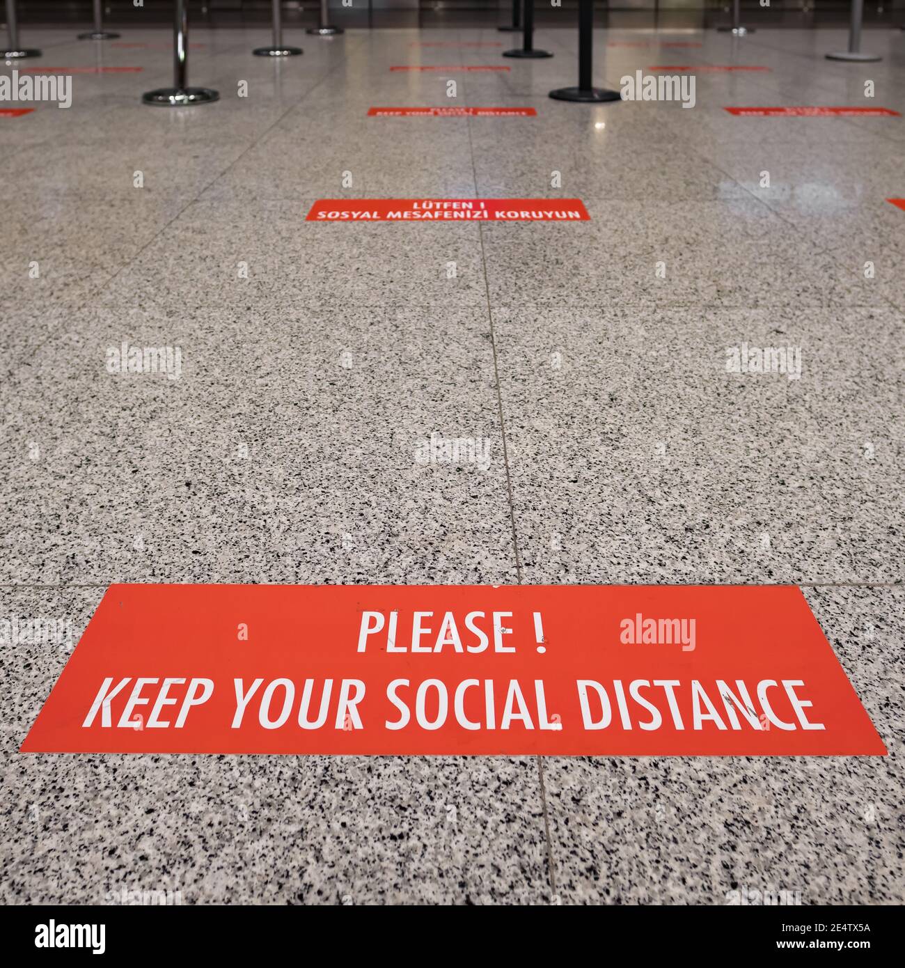 Segni sul pavimento circa l'allontanamento sociale durante la pandemia di Covid-19 Foto Stock
