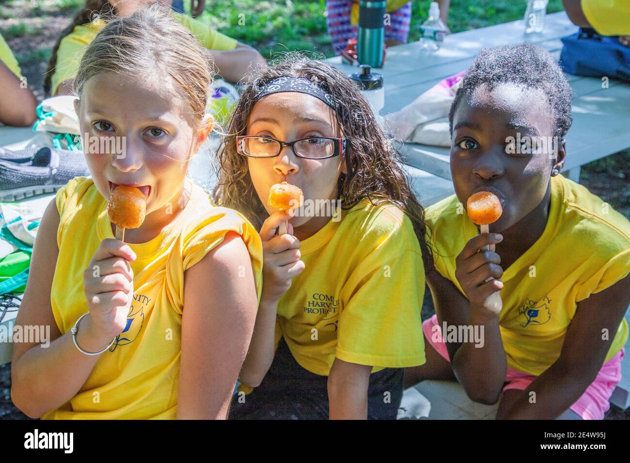 Tre giovani ragazze che mangiano un papsicle in un'estate calda giorno Foto Stock