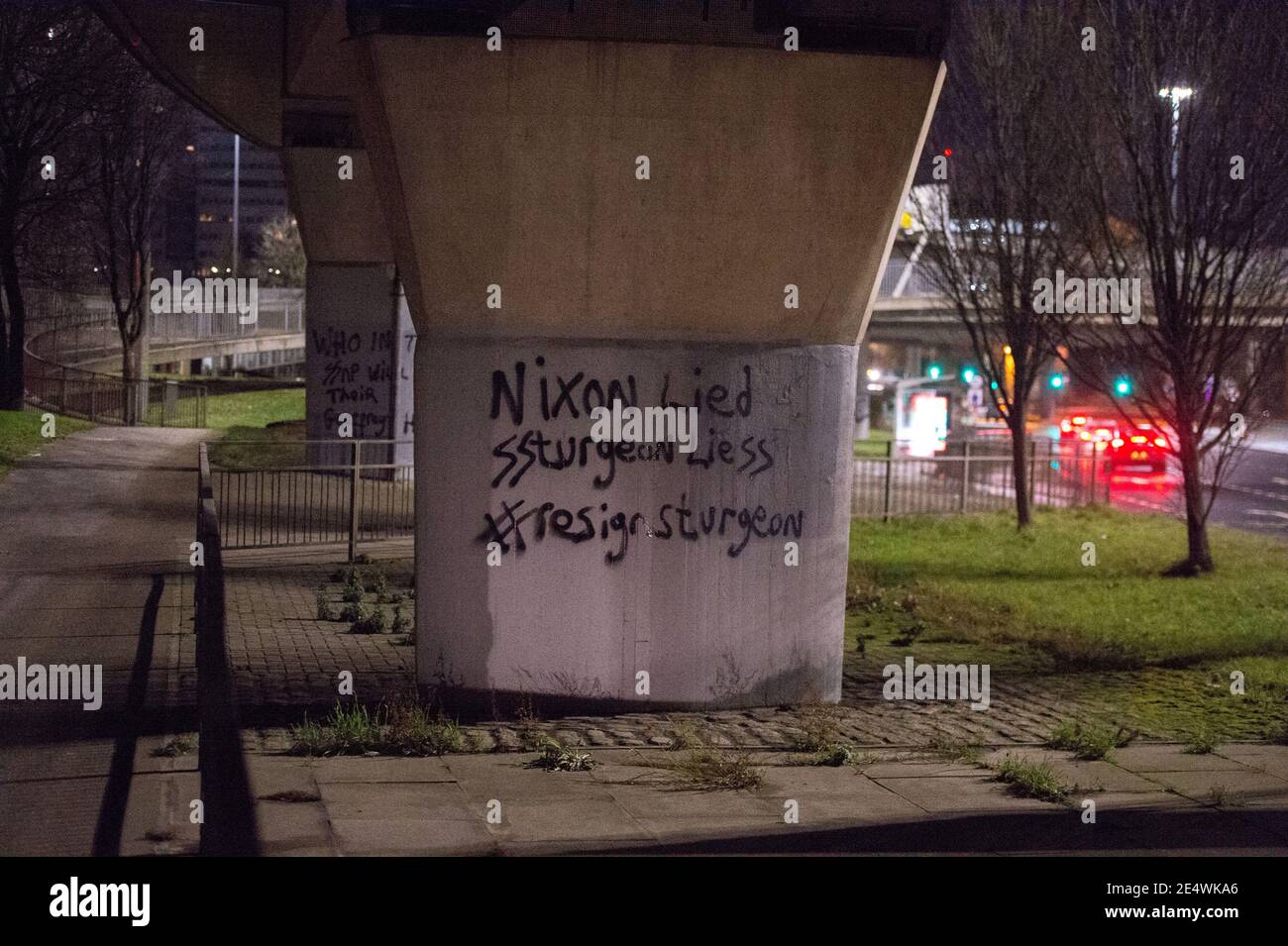 Glasgow, Scozia, Regno Unito. 25 Gennaio 2021. Nella foto: ‘Clydebanksy', che trae ispirazione dal nome Banksy l'artista, si vede spruzzare uno slogan su una delle colonne del Kingston Bridge che recita: "NIXON LIED SSTURGEON LIESS n. RASSEGNAZIONE STORIONE". Egli ha dipinto nello Schutzstaffel AKA il doppio ‘SS' con le parole ‘Sturgeon' e la parola ‘bugie' per fare un punto su come ritiene che la SNP stia gestendo il paese. Credit: Colin Fisher/Alamy Live News Foto Stock