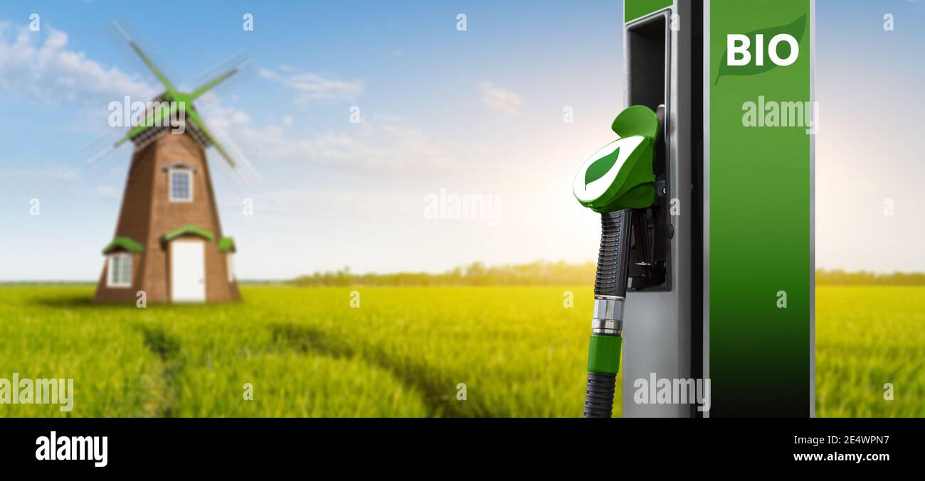 Stazione di riempimento biocarburante su uno sfondo di campo verde con mulino a vento Foto Stock