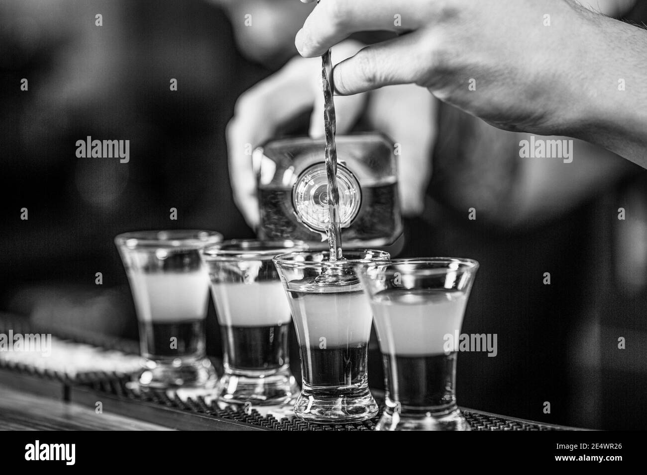 Scatti al nightclub. Cocktail rosso al nightclub. Barman che prepara il cocktail shooter. Barista che versa una bevanda alcolica forte in piccoli bicchieri Foto Stock