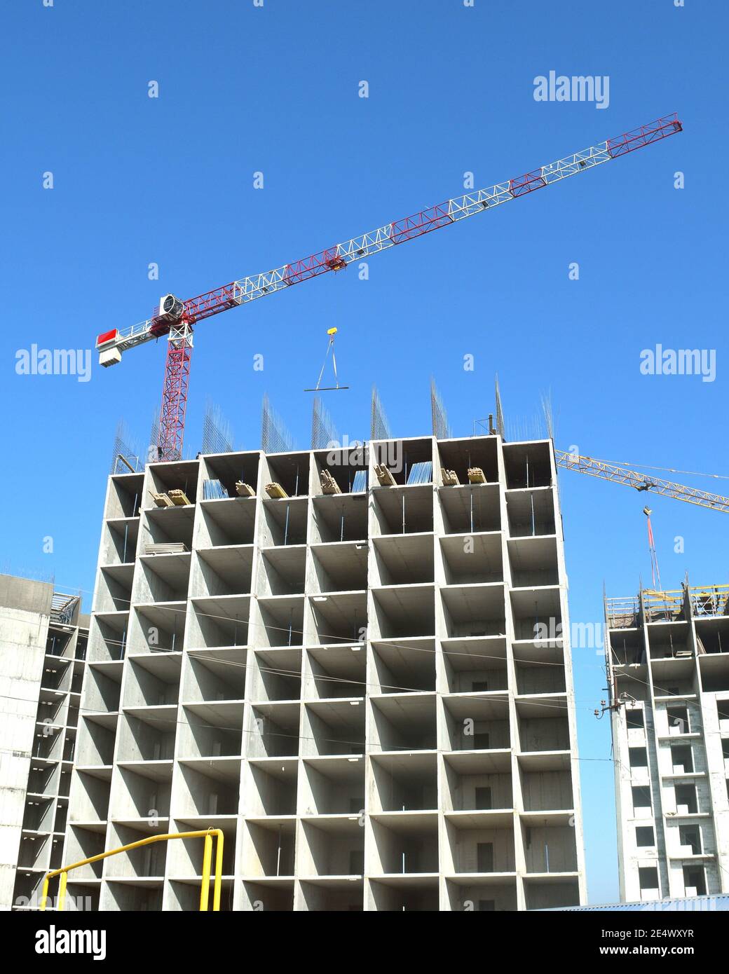 cantiere edile con gru a torre su cielo blu chiaro sfondo Foto Stock