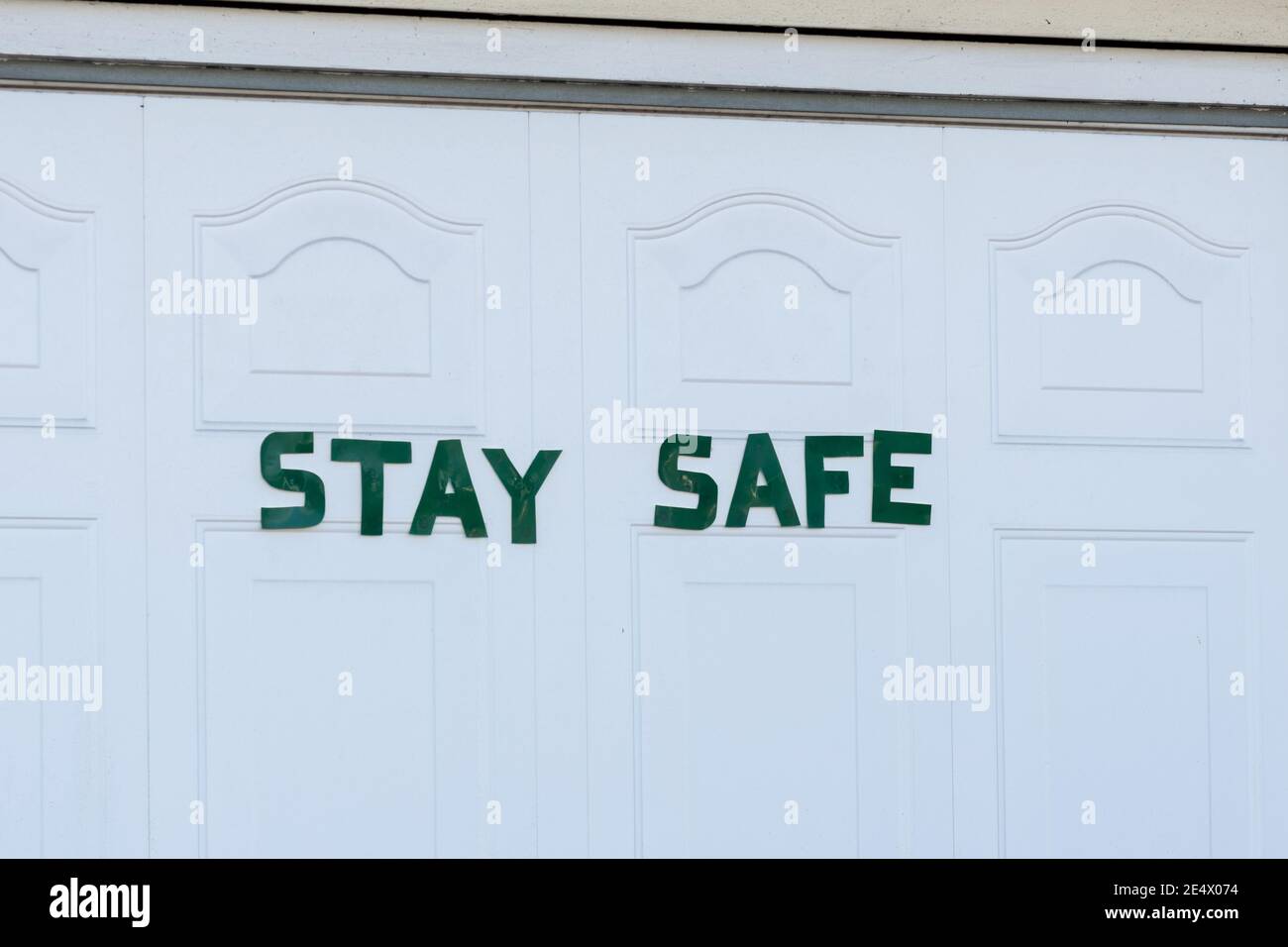 Rimani sicuro, parole postate su una porta bianca del garage durante il coronavirus covid-19 pandemic, 2020, 2021 Foto Stock