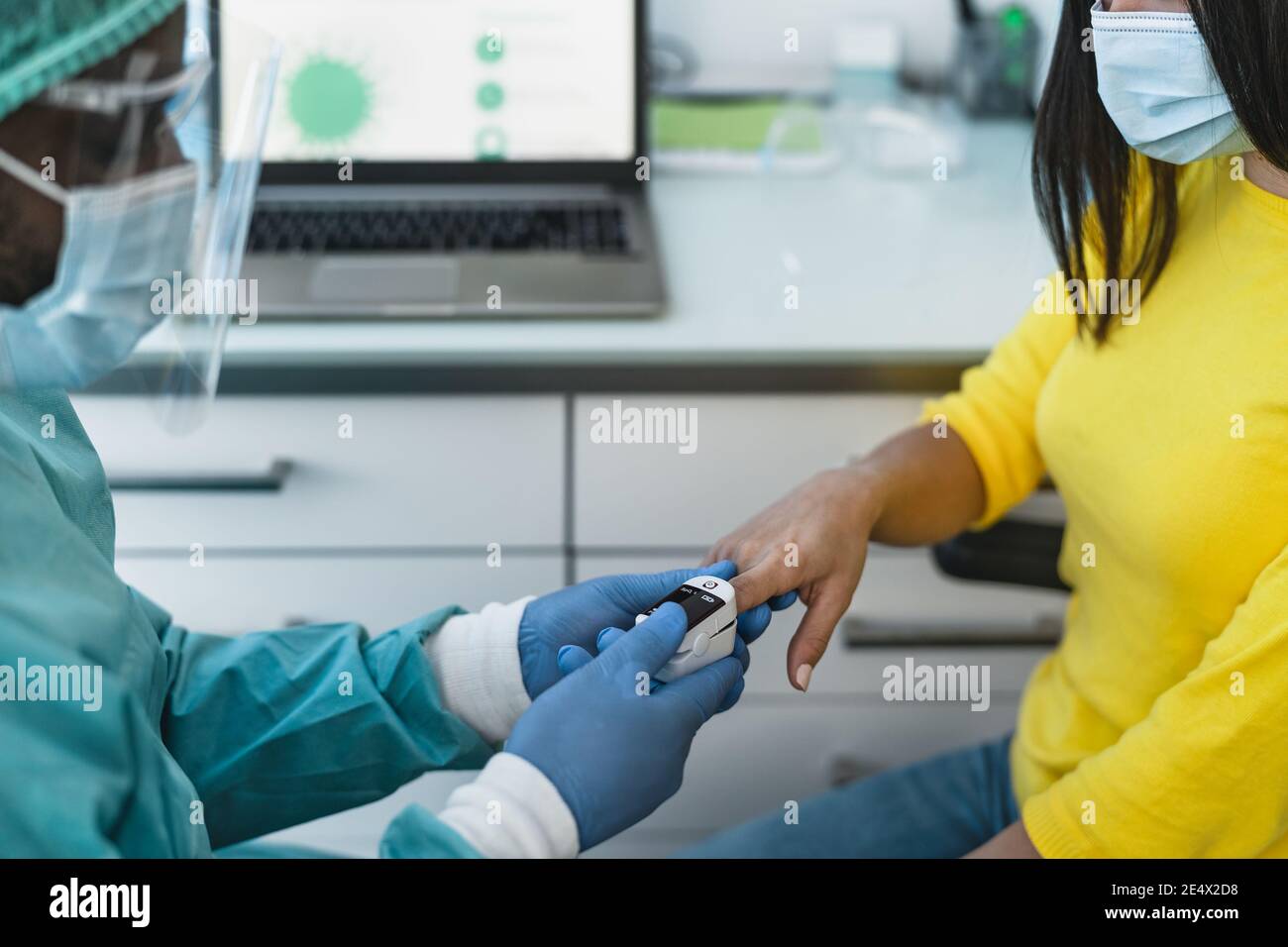 Operaio medico che esamina l'ossigenazione alla paziente di sesso femminile con il nuovo ossimetro dispositivo durante l'epidemia di virus corona Foto Stock