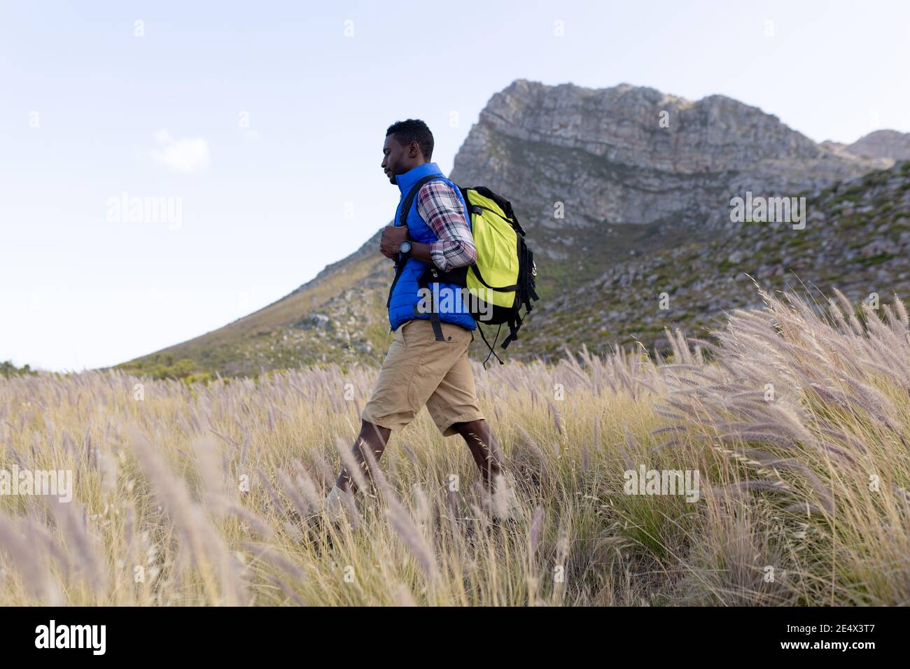 Fit afrcan americano uomo indossando zaino escursionismo in campagna di montagna Foto Stock