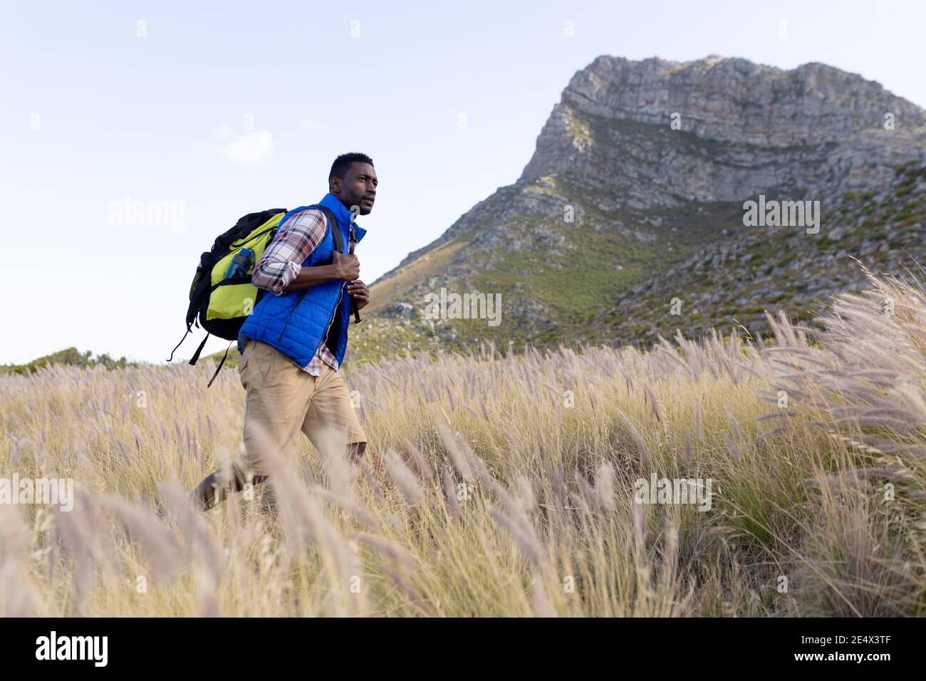 Fit afrcan americano uomo indossando zaino escursionismo in campagna di montagna Foto Stock