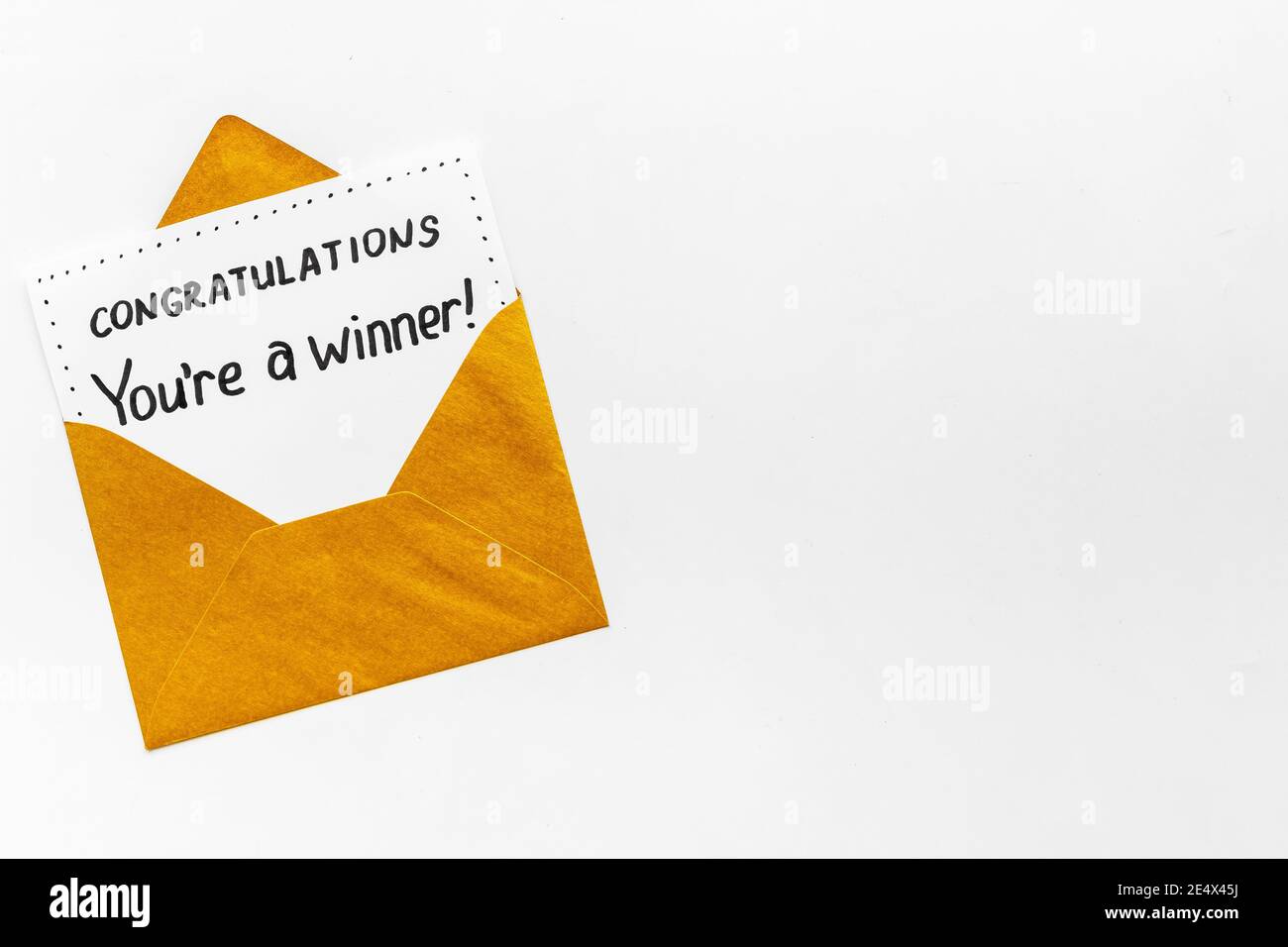 Sei un vincitore. Busta dorata con carta di congratulazioni. Vista dall'alto Foto Stock