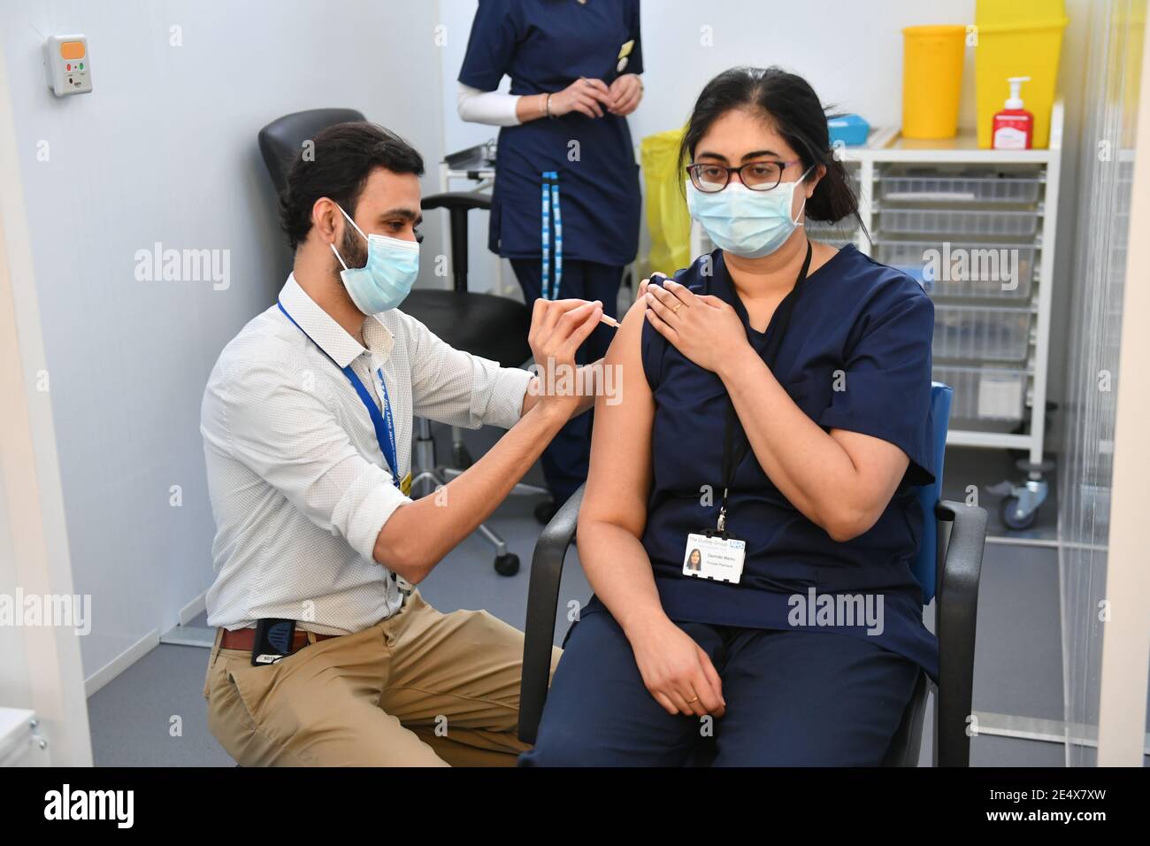 Il principale farmacista Davinder Manku (a destra) riceve un'iniezione del vaccino Oxford/AstraZeneca coronavirus al Black Country Living Museum di Dudley. Il museo all'aria aperta, precedentemente utilizzato come set per la serie di blinders paky dramma della BBC, è ora utilizzato come centro di vaccinazione covid. Data immagine: Lunedì 25 gennaio 2021. Foto Stock
