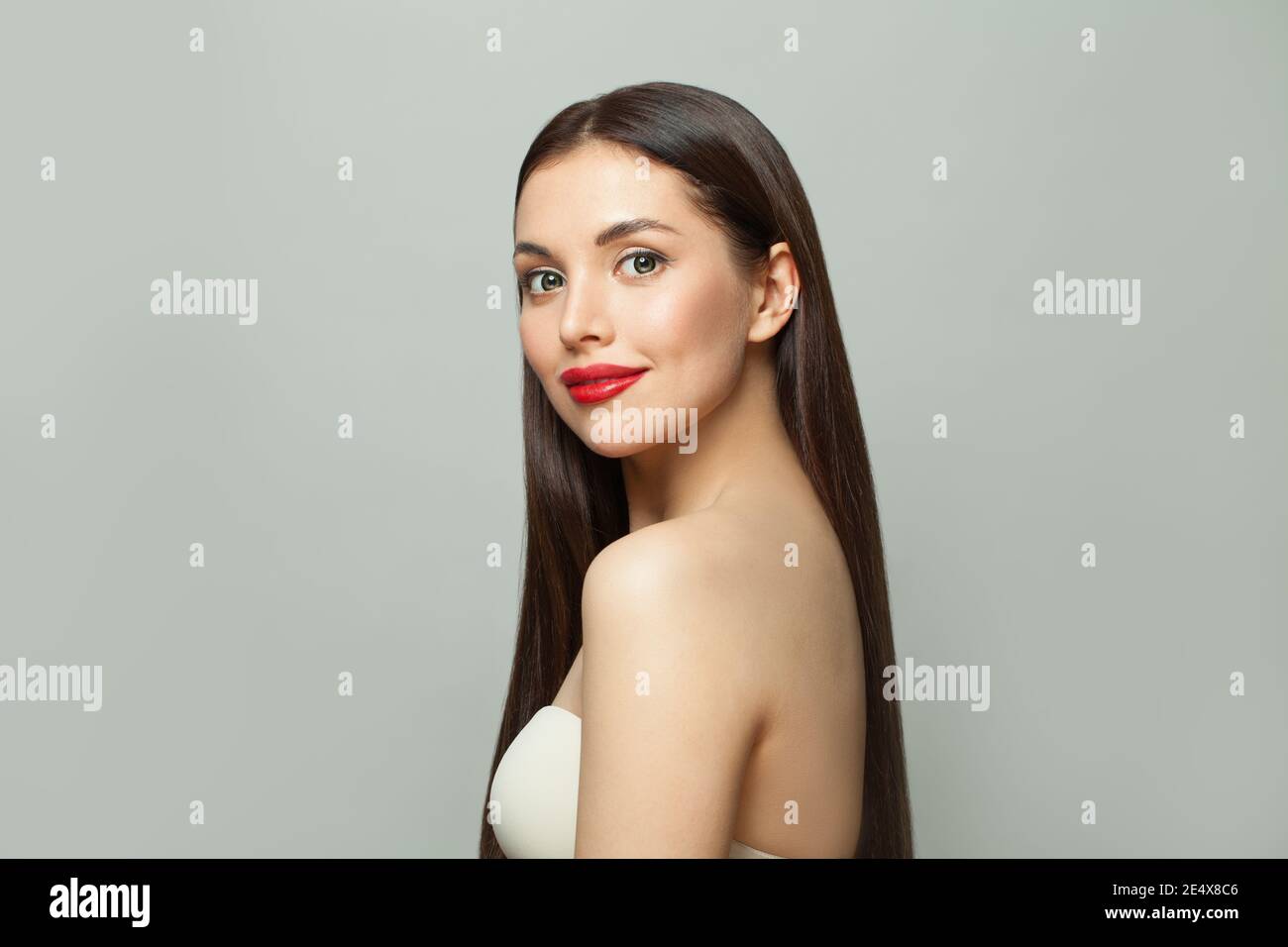 Ritratto di bellezza di attraente modello sano donna con pelle chiara e lunghi capelli lisci e luminosi su sfondo bianco Foto Stock