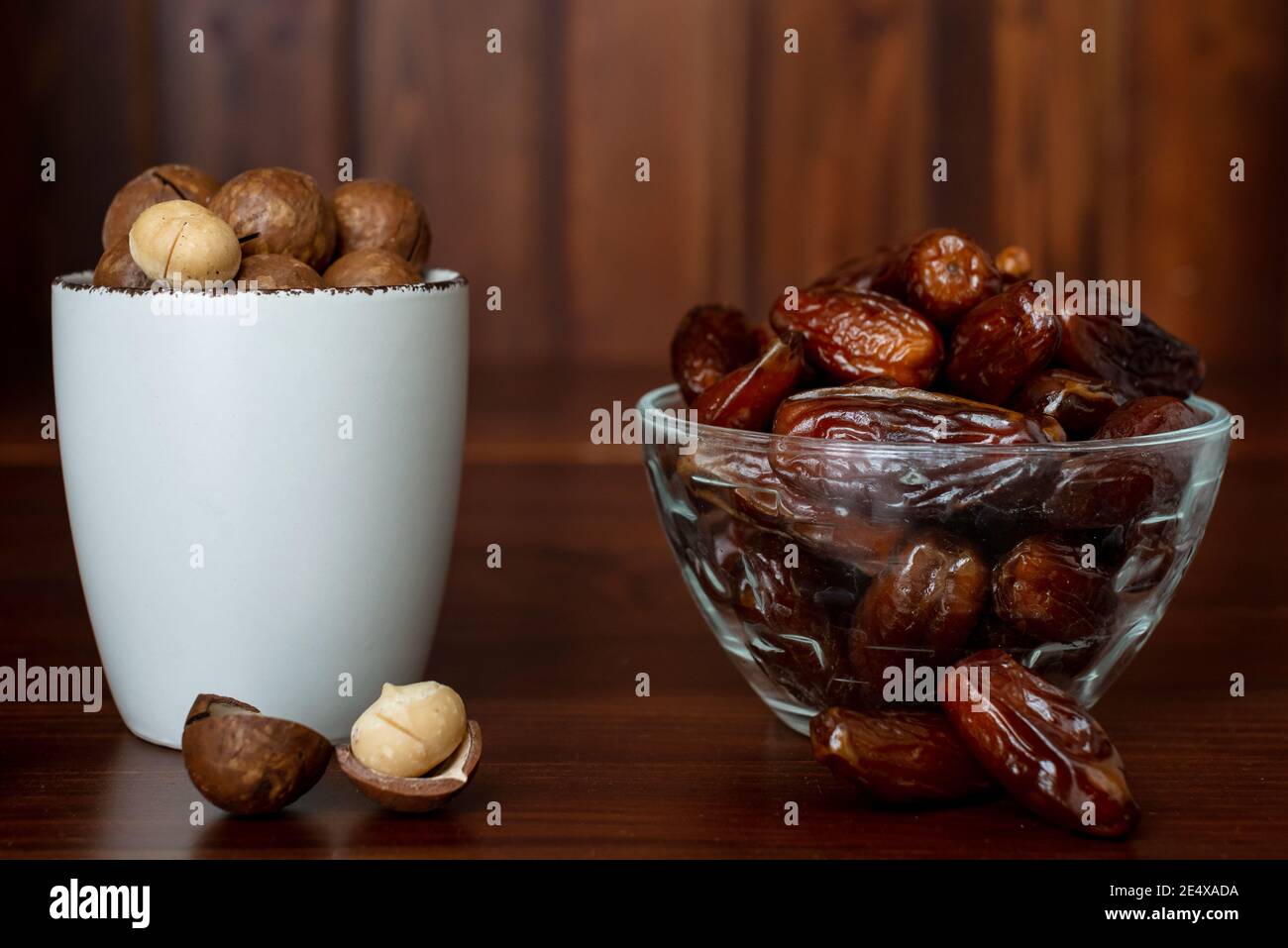 Concetto di snack sano. Messa a fuoco selettiva. Noci di macadamia e frutta di palma di dattero. Primo piano di frutta secca e noci Foto Stock