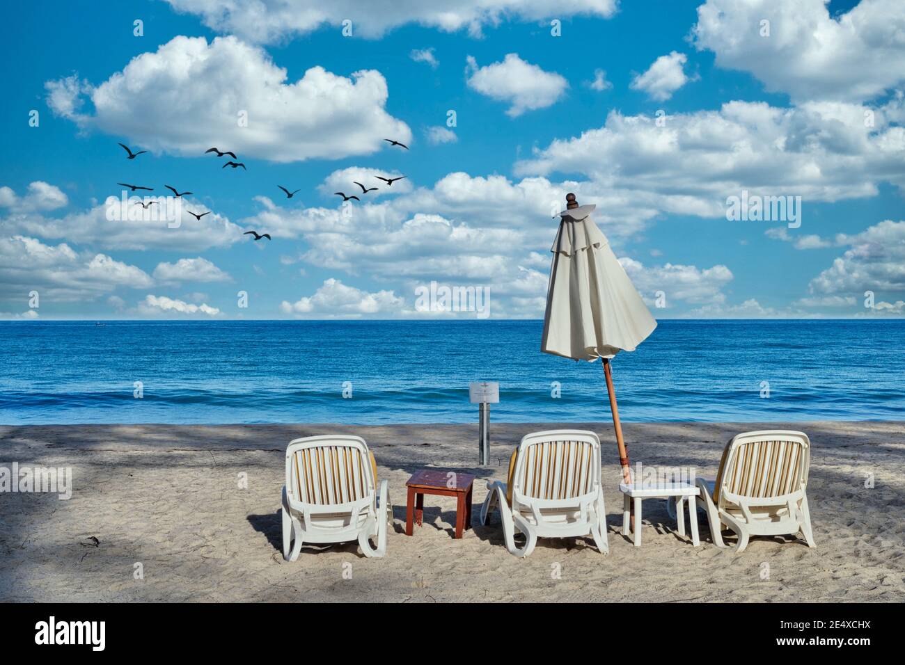 Sedie da spiaggia e un ombrellone su una spiaggia altrimenti vuota Bang Tao, Phuket, Thailandia Foto Stock