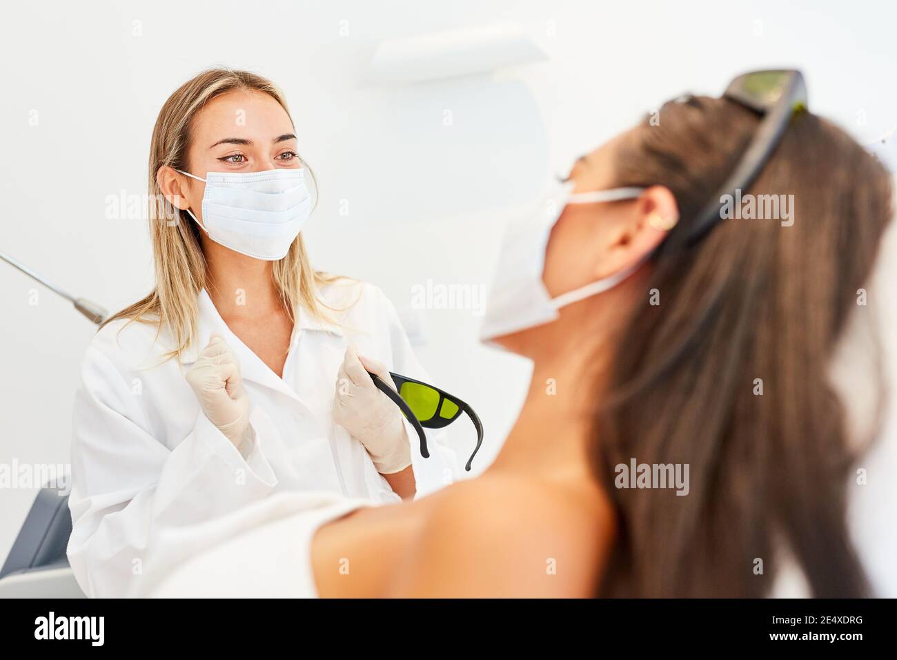 Dermatologo e paziente con maschera a causa di Covid-19 in una consultazione Foto Stock