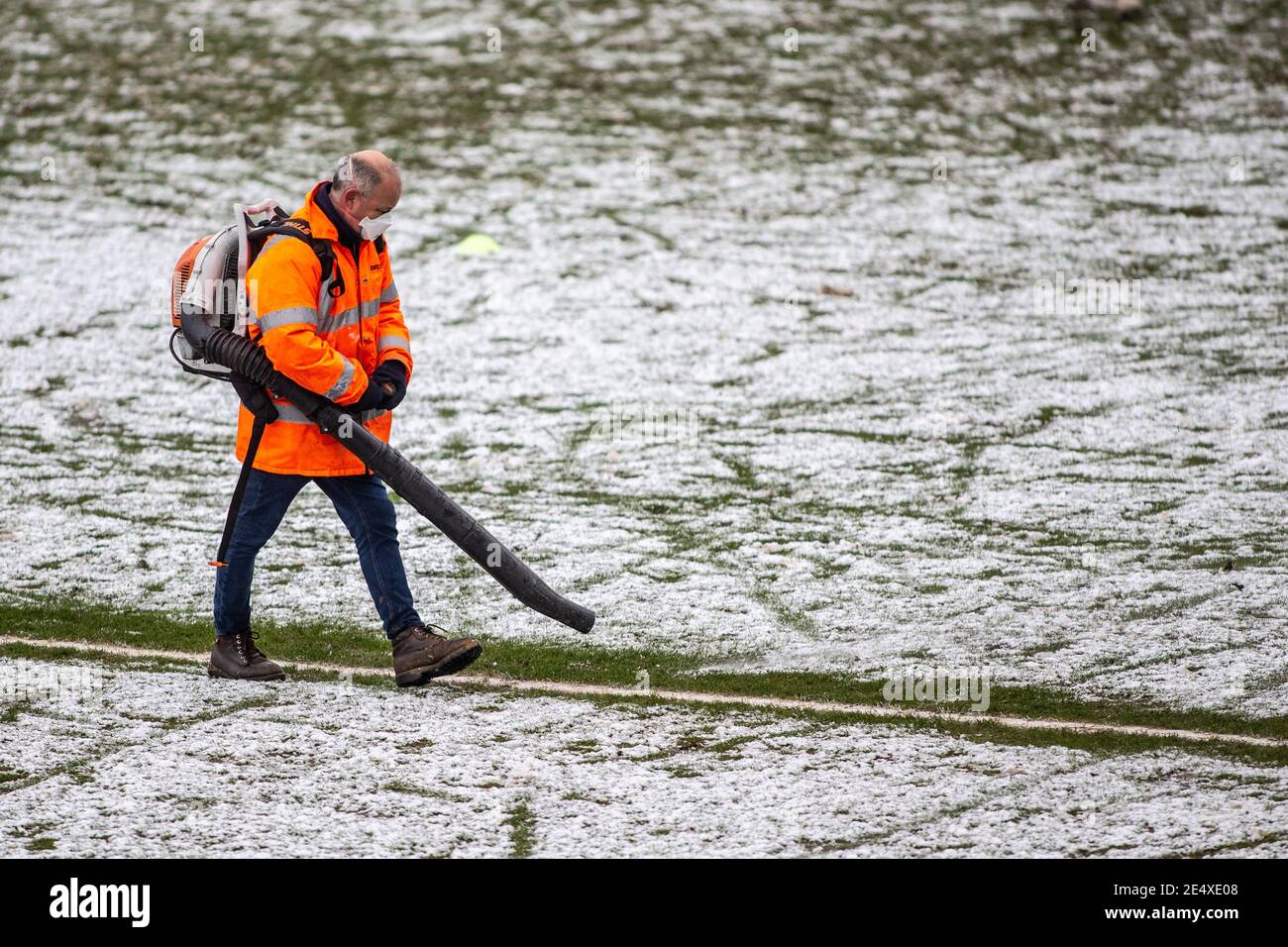 Il personale di terra dello stadio di calcio libera la neve dal campo prima della partita. Foto Stock