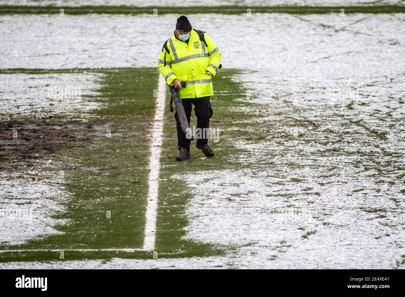 Il personale di terra dello stadio di calcio libera la neve dal campo prima della partita. Foto Stock