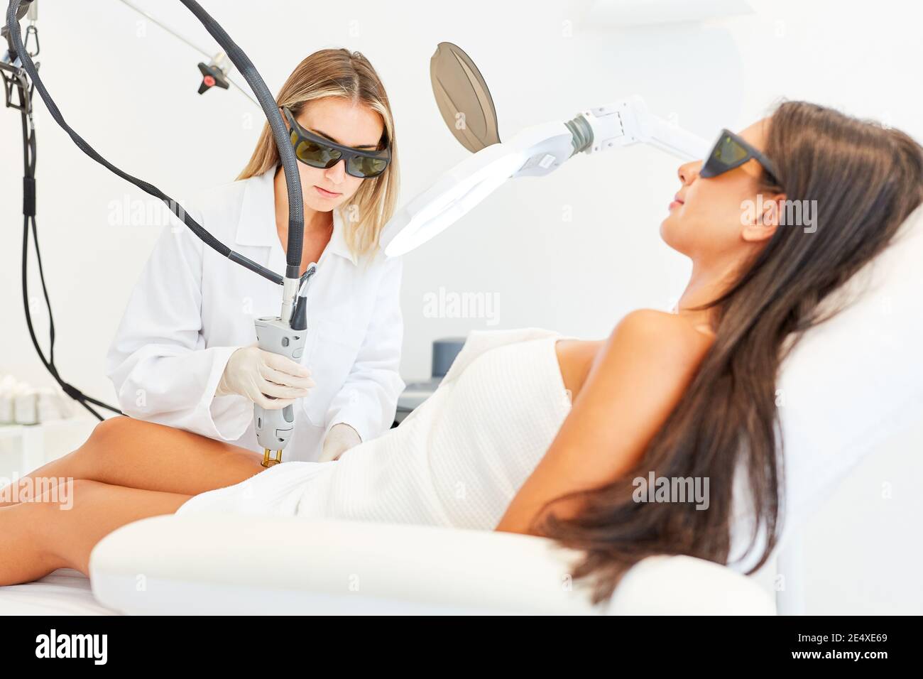 Paziente femminile con epilazione sulla coscia con alexandrite laser nello studio cosmetico Foto Stock