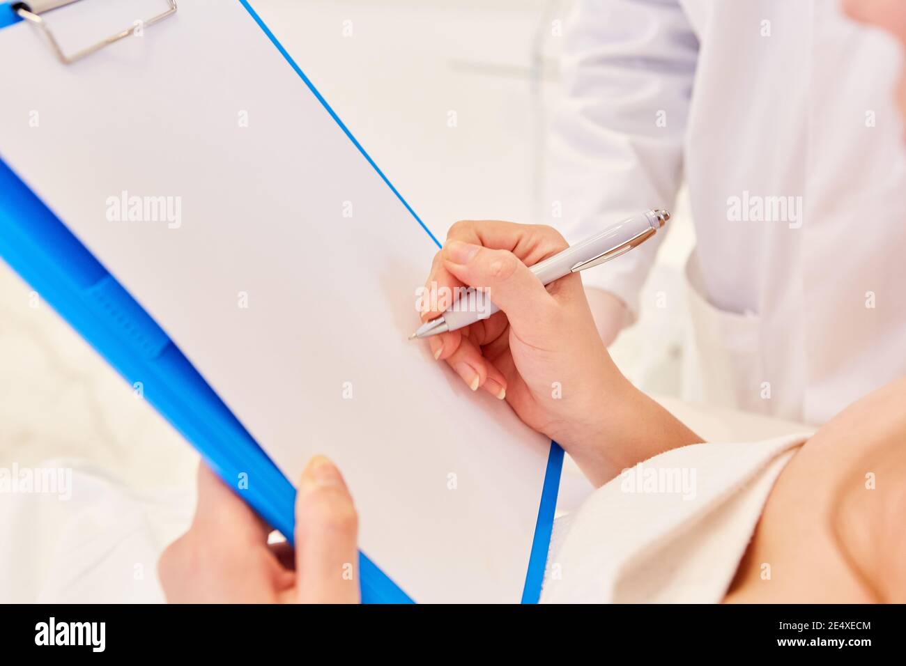 Paziente femminile con penna quando si firma un contratto di trattamento per un'operazione Foto Stock