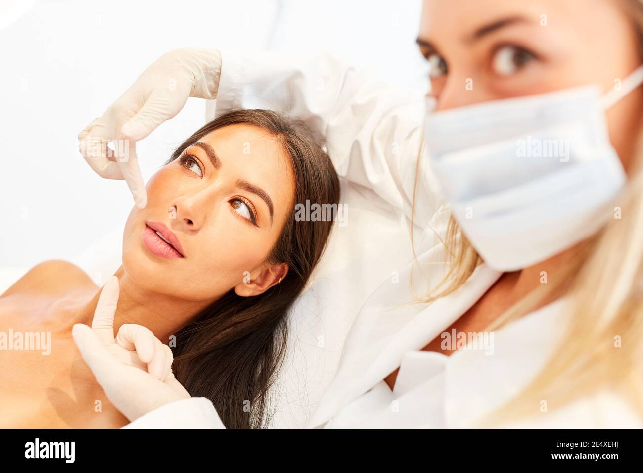 Giovane donna come paziente con dermatologist durante la consultazione sulla pelle serraggio sulla superficie Foto Stock
