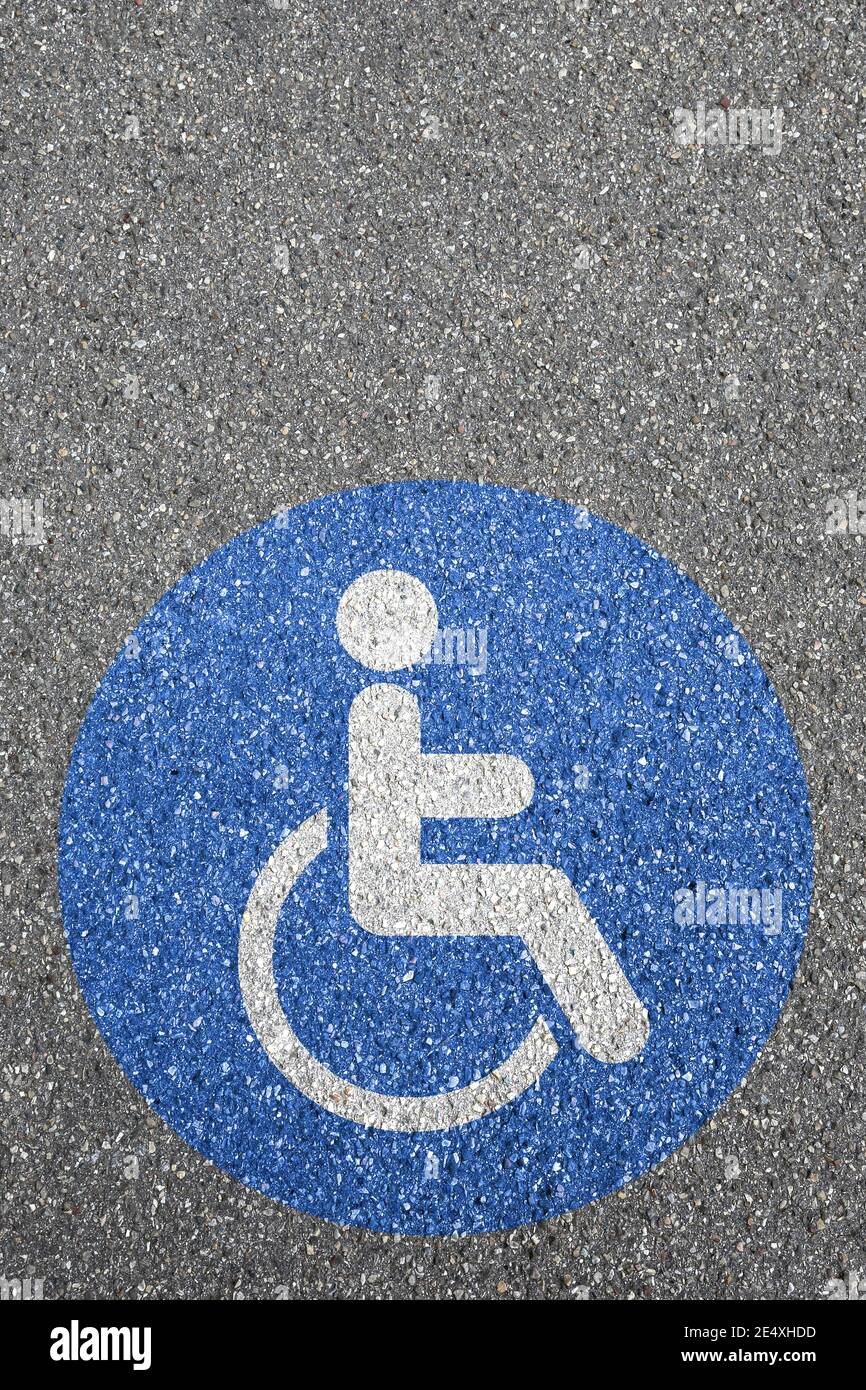 Uomo persone sedia a rotelle segnaletica stradale disabili copyspace spazio copia disabili area strada con sedia a rotelle Foto Stock