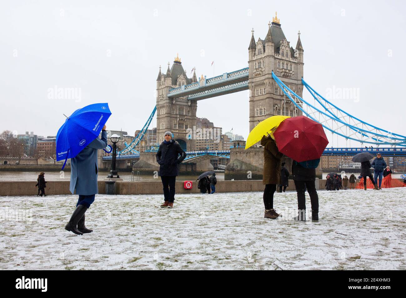 La gente ha coraggioso il tempo per posare per le fotografie al Tower Bridge a Londra. Foto Stock