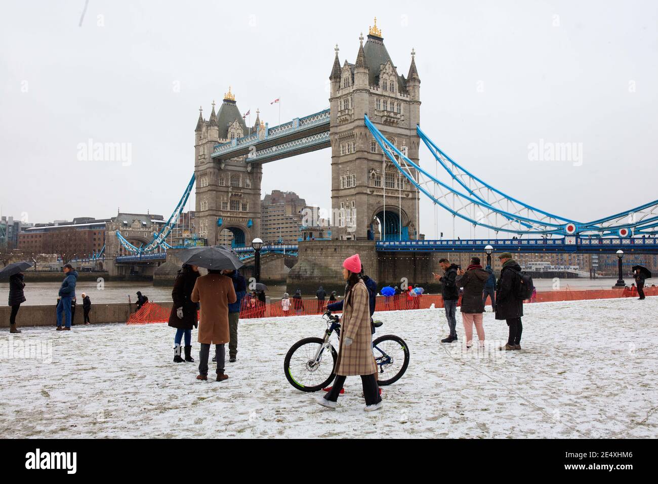 La gente ha coraggioso il tempo per posare per le fotografie al Tower Bridge a Londra. Foto Stock