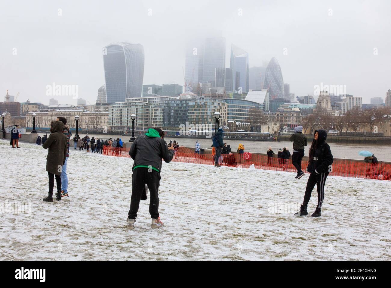Le persone si fermano per scattare fotografie sulla neve con una vista della città a Potters Field, Londra. Foto Stock
