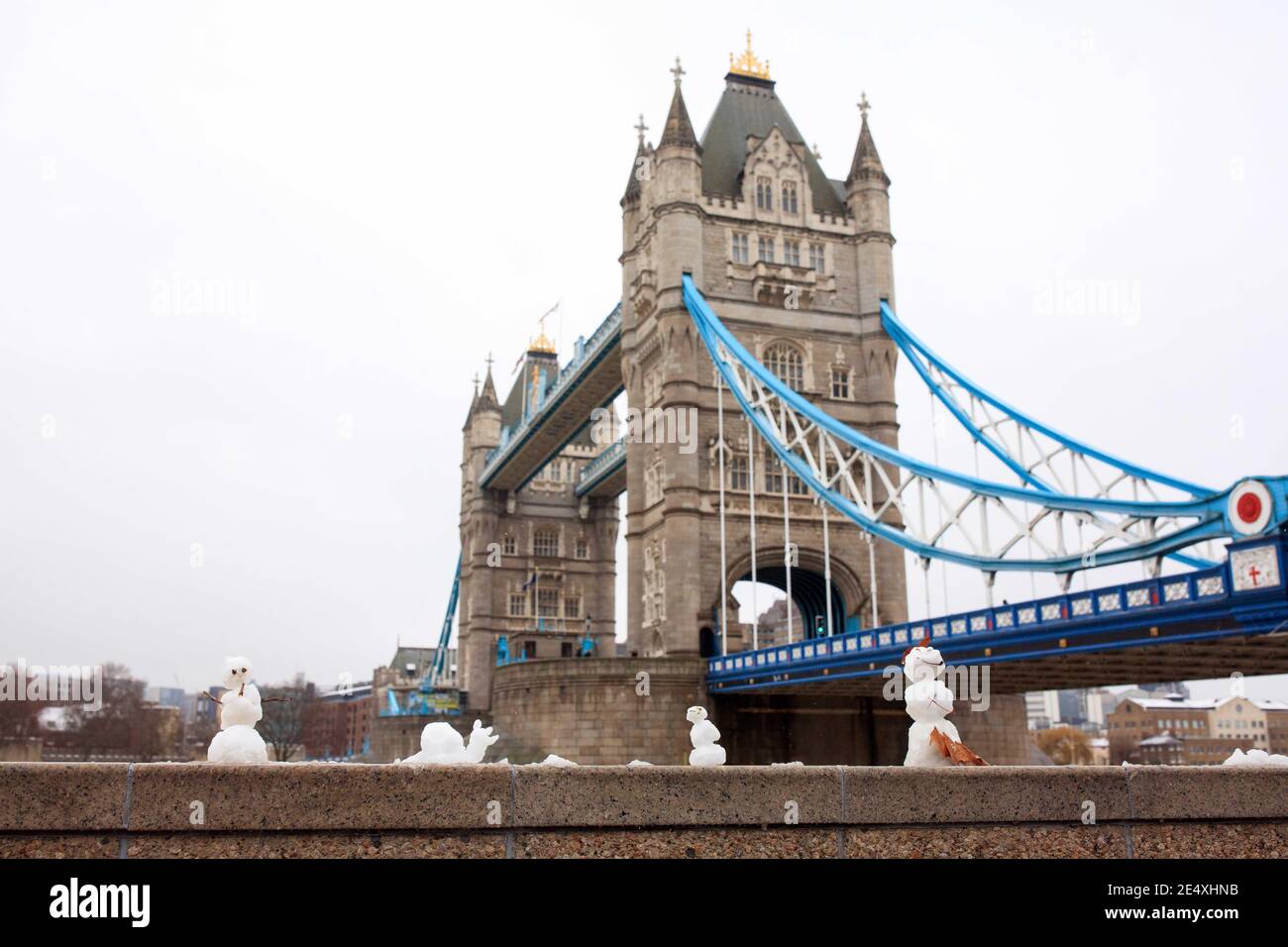 Una galleria di pupazzi di neve in miniatura è apparsa sul muro vicino a Tower Bridge a Potters Field, Londra. Foto Stock