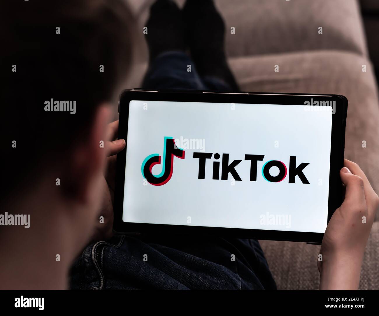 Bambino che naviga nei video TikTok su un tablet. Profondità di campo poco profonda. Foto Stock