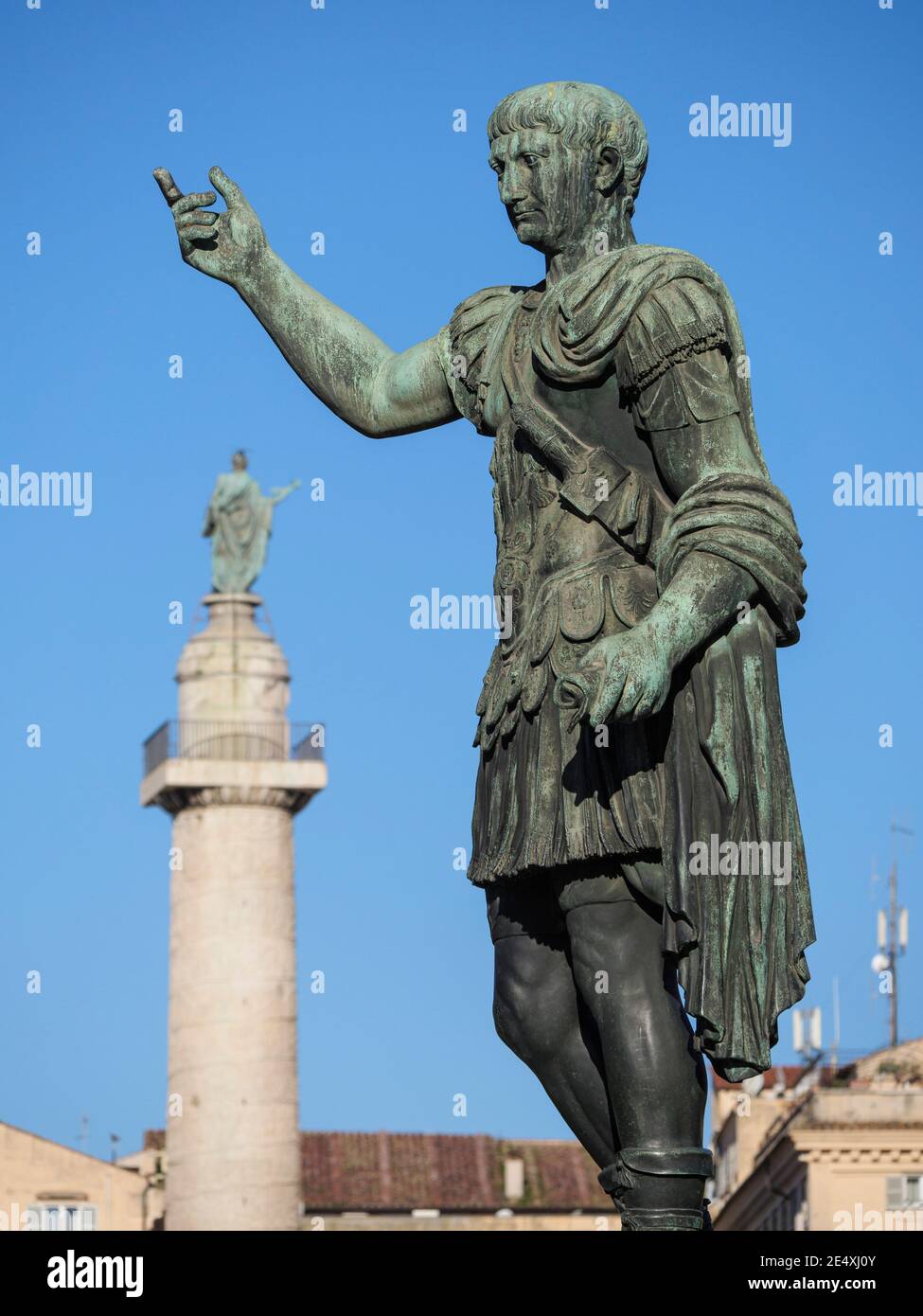 Roma. Italia. Statua in bronzo dell'imperatore romano Traiano su Via dei fori Imperiali, la colonna di Traiano è sullo sfondo. 13° Imperatore dell'Impero Romano Foto Stock