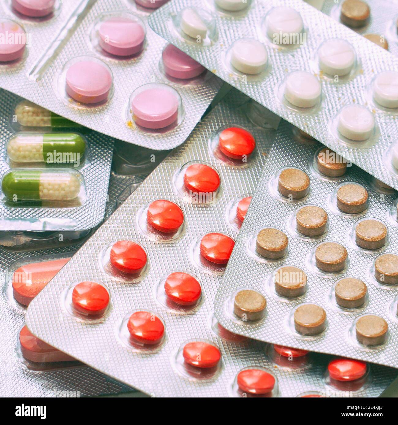 Compresse e capsule di diversi colori confezionate in blister. Informazioni farmaceutiche o mediche Foto Stock